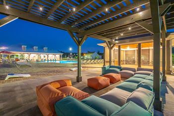 a patio with couches and a pool at nightScreened-in patio and social space at Anthem Apartments and Luxury Rentals in Huntsville, AL